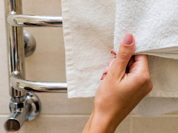 istock Chrome towel rail. A woman is holding a towel. Cropped image. 856458424