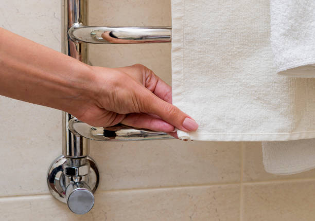 istock Chrome towel rail. A woman is holding a towel. Cropped image. 856458426