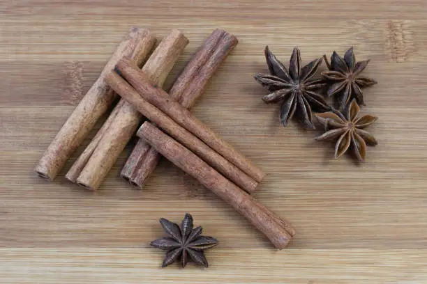 Cinnamon sticks with star anise on brown bamboo board. Aroma spice on a brown background.