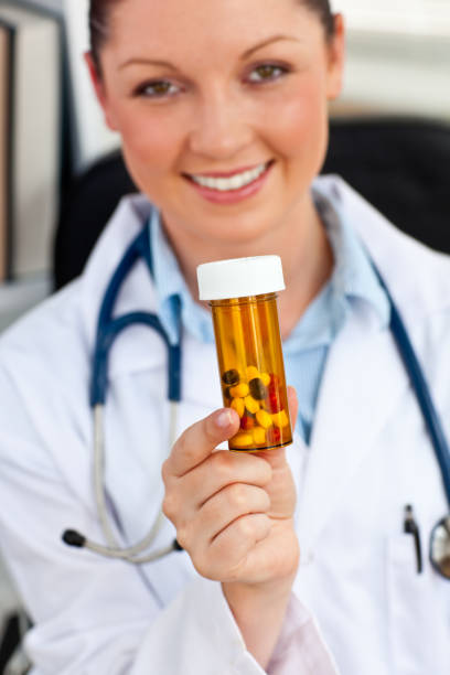 istock Delighted female doctor holding pills into the camera 856479792