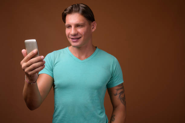 istock Studio shot of muscular man using mobile phone against colored background 856481296