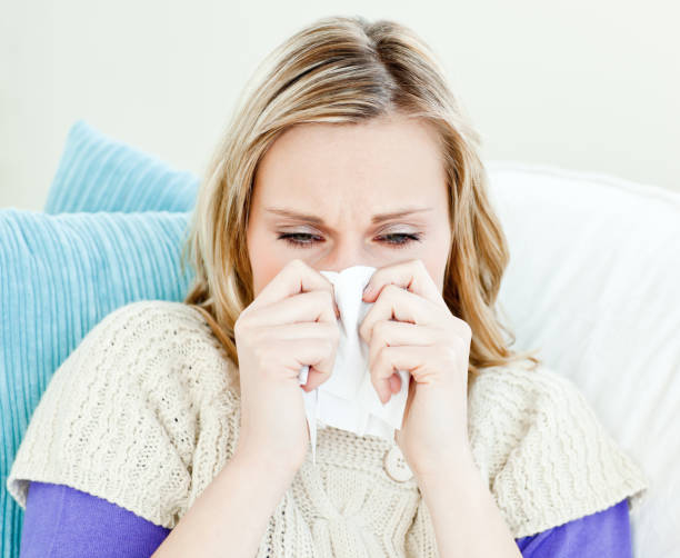 istock Portrait of a sick pretty woman blowing lying on a sofa 856484012