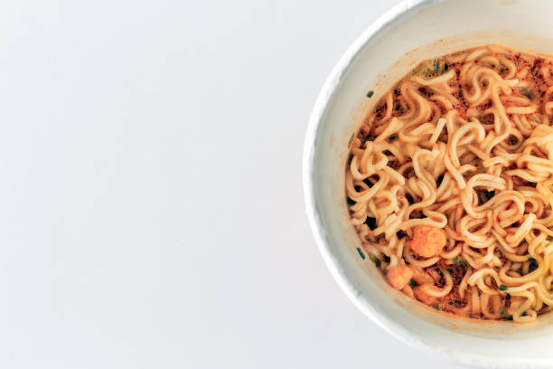istock closeup mama or noodle in cup and tomyam soup on white table with sofe-focus and over light in the background 856484208