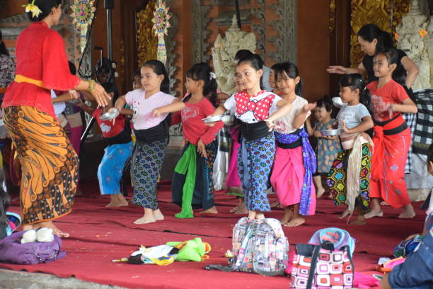 ubud, bali, indonesia - 20 agosto 2017 - bella donna insegna danza balinese ai bambini piccoli - danza del legong immagine foto e immagini stock