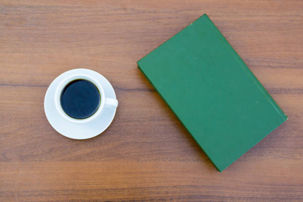 istock Cup of coffee and closed book on wooden table 856493312