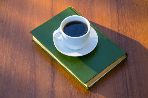 istock Cup of coffee and book on wooden table 856493314