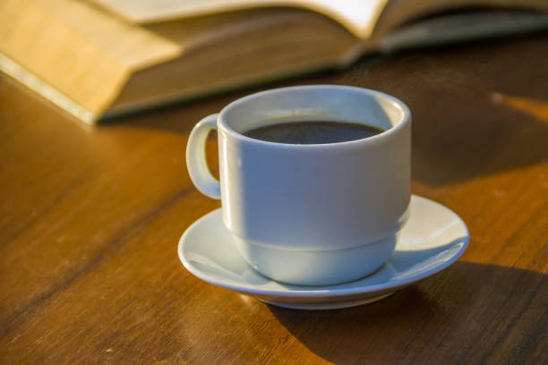 istock Cup of coffee and book on wooden table 856493328
