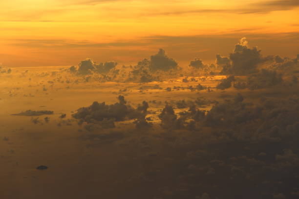 Sunset reflect Dense Fluffy Puffs of White Clouds red sky at high level attitude, view from window airplane so Unsharp and Noise, copy space