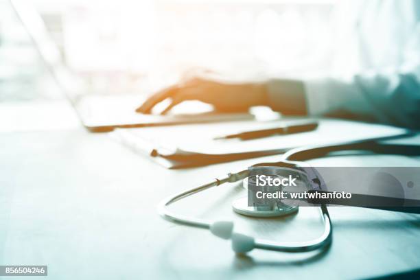 Doctor Using Laptop At Desk In Clinic Working On Computer At Room Office Stock Photo - Download Image Now