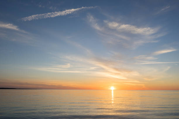 istock Evening sunlight on coast, pink clouds, blue sky reflection on water. Beach in summer. Seaside natural environment. Shore in Kesselaid, small island in Estonia. Nature Reserve in North Europe 856506568