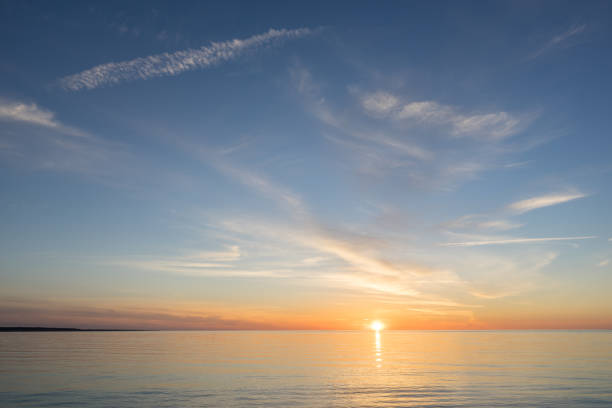 istock Evening sunlight on coast, pink clouds, blue sky reflection on water. Beach in summer. Seaside natural environment. Shore in Kesselaid, small island in Estonia. Nature Reserve in North Europe 856506586