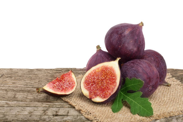 istock fig fruits with leaves on old wooden table with white background 856518094