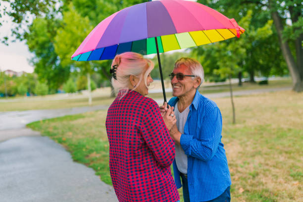 istock The old couple in the rain with umbrellas 856519628