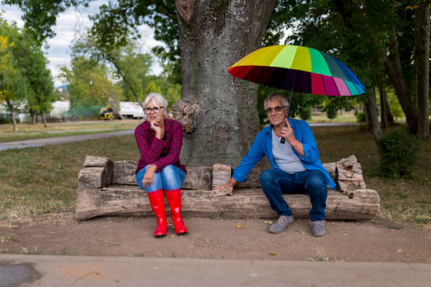 istock The old couple in the rain with umbrellas 856522356