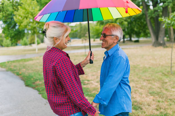 istock The old couple in the rain with umbrellas 856525780