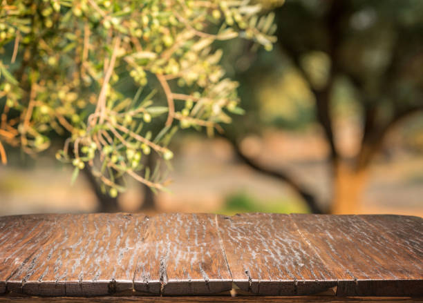 istock Olives with old wooden table. Blur nature background. 856526384
