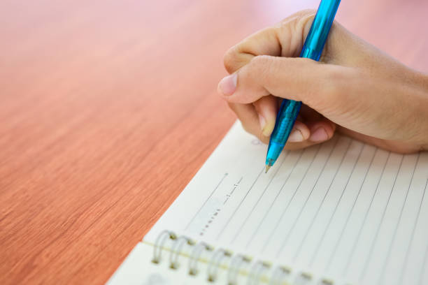 istock Close up Student writing something in notepad while sitting at the desk.Thailand 856534346