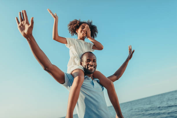 istock african american father carrying daughter on beach 856536700