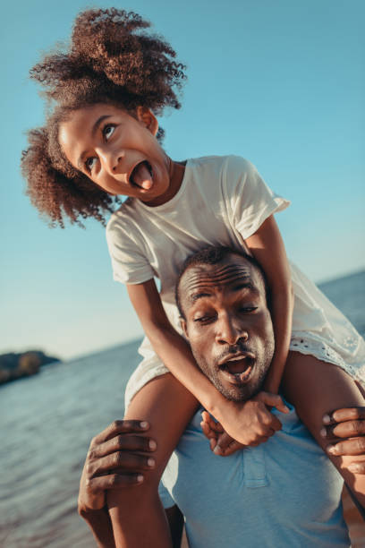 istock african american father carrying daughter on beach 856537004