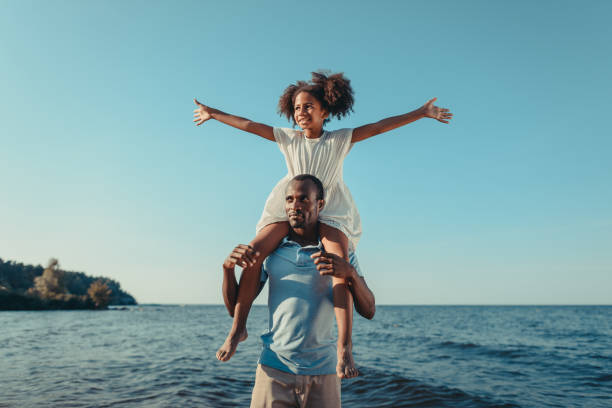 istock african american father carrying daughter on beach 856537306
