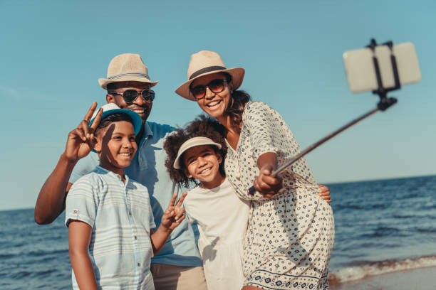 family taking selfie on beach happy african american family taking selfie with smartphone on beach the black womens expo stock pictures, royalty-free photos & images