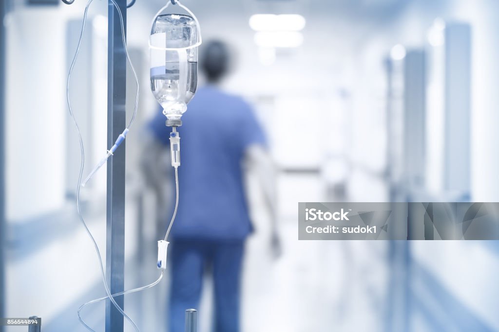 Drip on the background of doctor walking down the hall Drip on the background of doctor walking down the hall. Emergency Room Stock Photo
