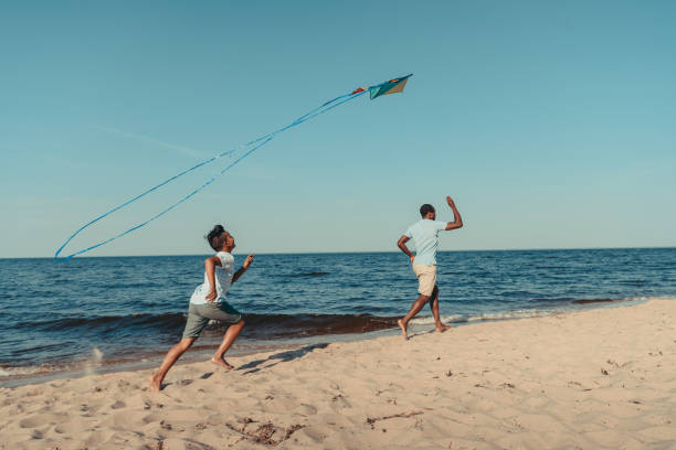istock father and son playing with kite on beach 856544950