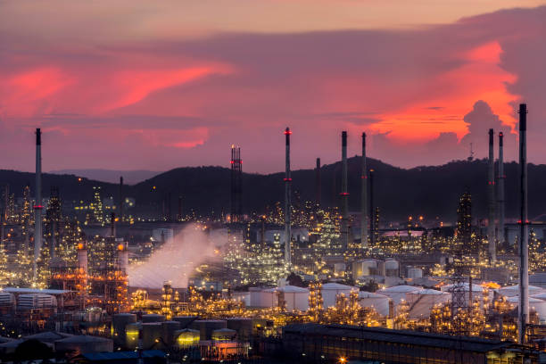 a large oil refinery near the community as the early evening light, or light twilight.the heat into steam flue. no blurring and soft focus - flue gas imagens e fotografias de stock