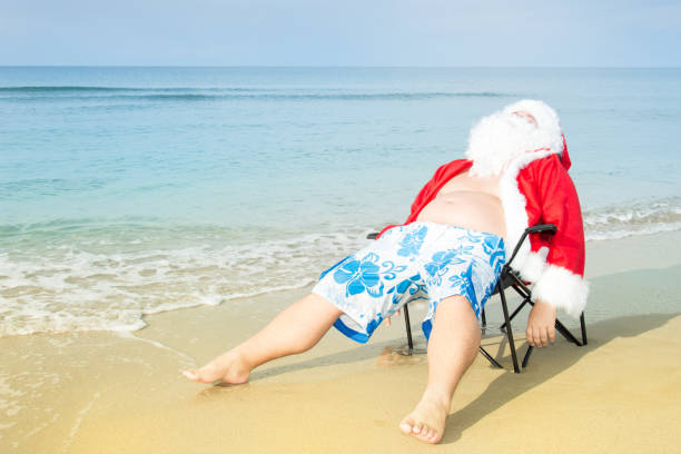funny santa in shorts on the beach. - christmas beach sun tropical climate imagens e fotografias de stock