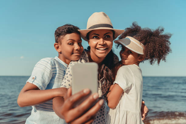 istock mother with kids taking selfie on beach 856549778