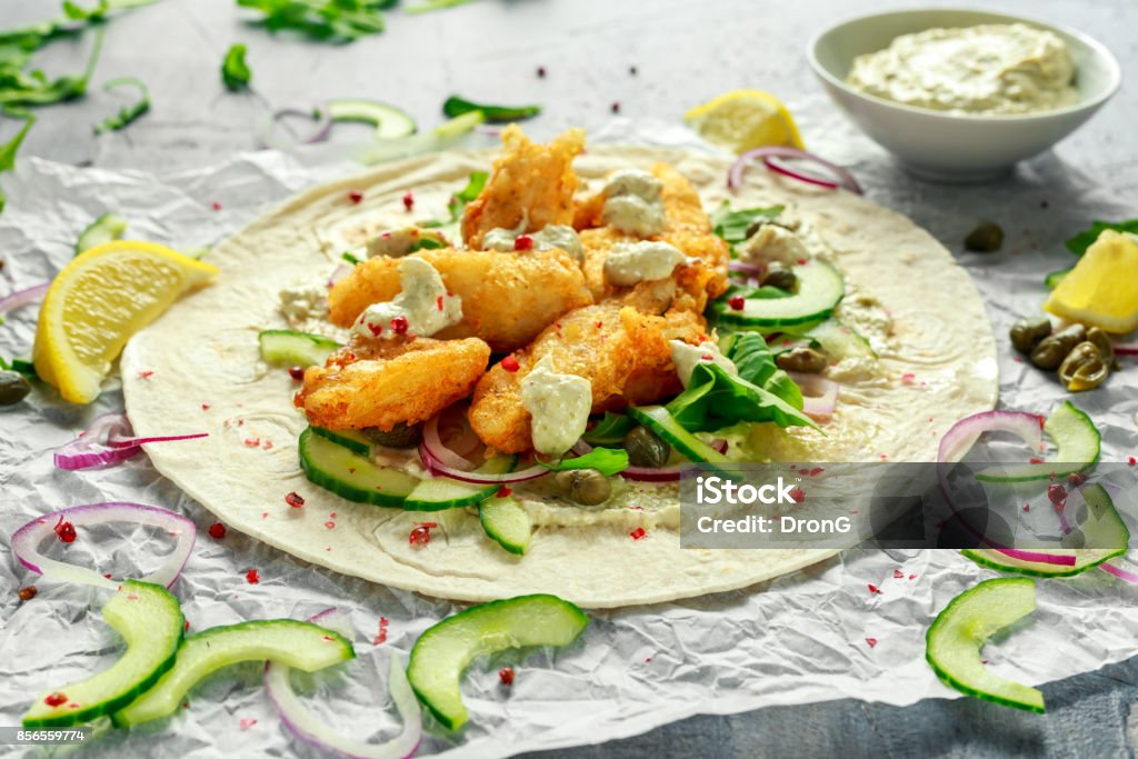 Fresh Fish Tortilla with cucumber, red onion, Capers, lemon, salad leaves and tartare sauce. Healthy Food Fresh Fish Tortilla with cucumber, red onion, Capers, lemon, salad leaves and tartare sauce. Healthy Food. Above Stock Photo Fresh Fish Tortilla with cucumber, red onion, Capers, lemon, salad leaves and tartare sauce. Healthy Food Fresh Fish Tortilla with cucumber, red onion, Capers, lemon, salad leaves and tartare sauce. Healthy Food. Above Stock Photo