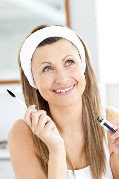istock Jolly young woman using mascara in the bathroom 856564696