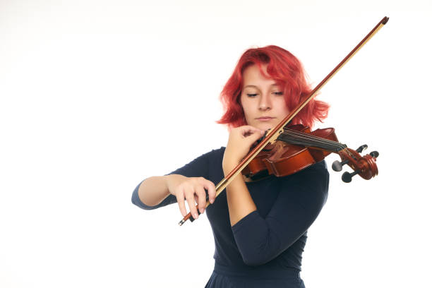 istock Beautiful young redhead woman playing the violin 856565076