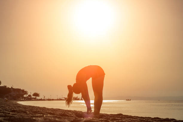 istock Athlete in downward facing dog position on shore 856572666