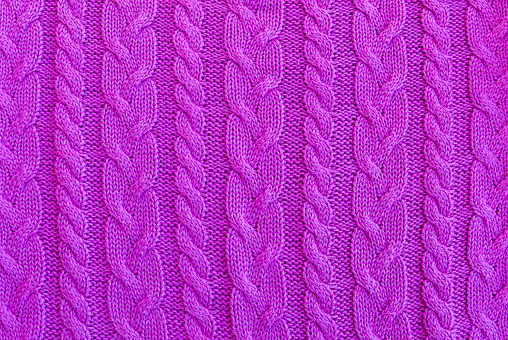 Knitted sweater in purple color, pattern detail. Can be used as background.