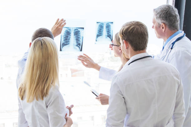 istock Group of doctors discuss x-ray 856575228