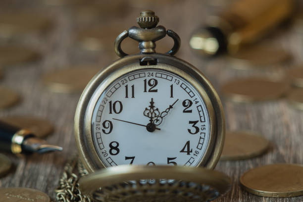 istock Pocket watch and coins on a wooden background 856576030