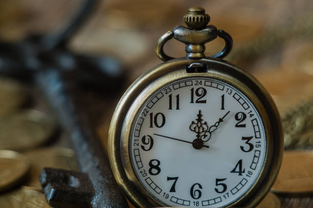 istock Pocket watch and coins on a wooden background 856576126