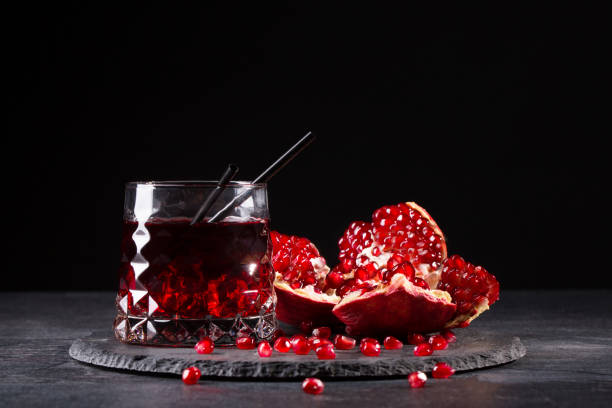 istock A composition of a pomegranate drink and cut garnet on a black background. Refreshing red cocktails. 856579410