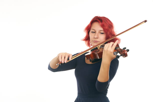 Beautiful young redhead woman playing the violin