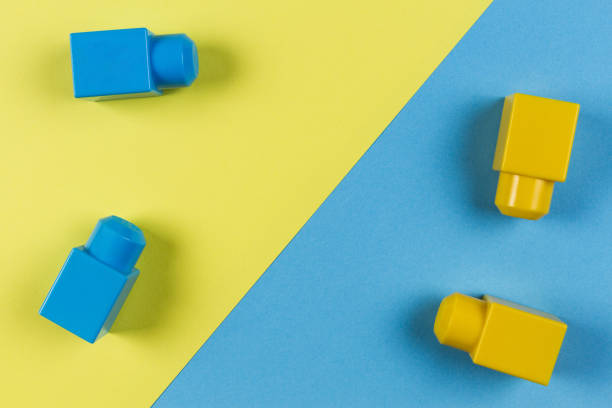 istock Blue and yellow plastic construction blocks on yellow and blue background 856585352