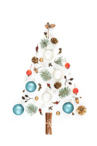 New year tree made of Christmas decorations. New year tree made of winter things, Christmas decorations,"nacorns, cones, spruce, apples on white background. "nChristmas, Holiday symbol. Flat lay. rose christmas red white stock pictures, royalty-free photos & images