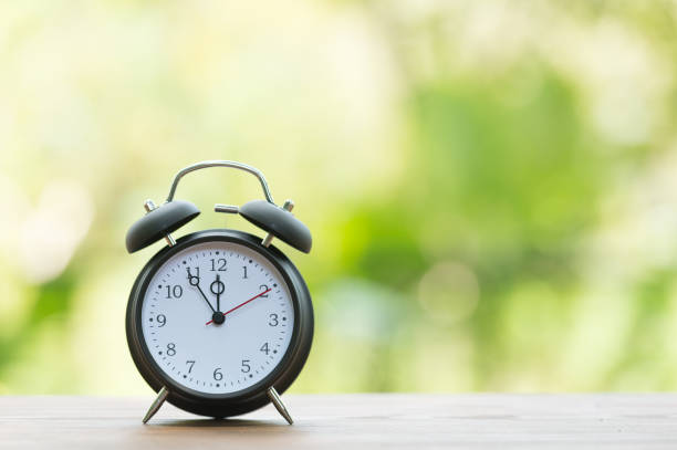 istock Retro alarm clock with five minutes to twelve o'clock. 856585946