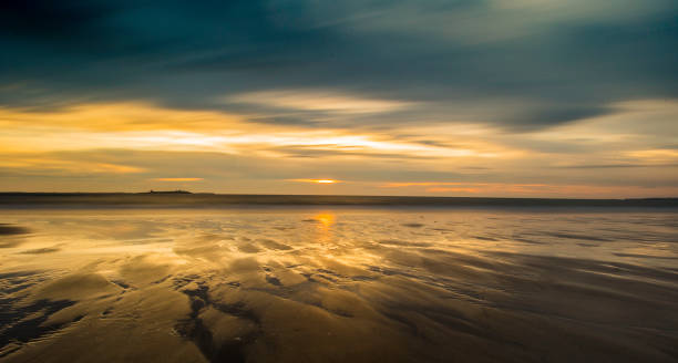 istock Sunrise & cloud blur over Bamburgh beach, Northumberland. 856586124
