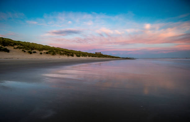 istock Pink Sky Reflections in the shoreline, Bamburgh, Northumberland. 856586146