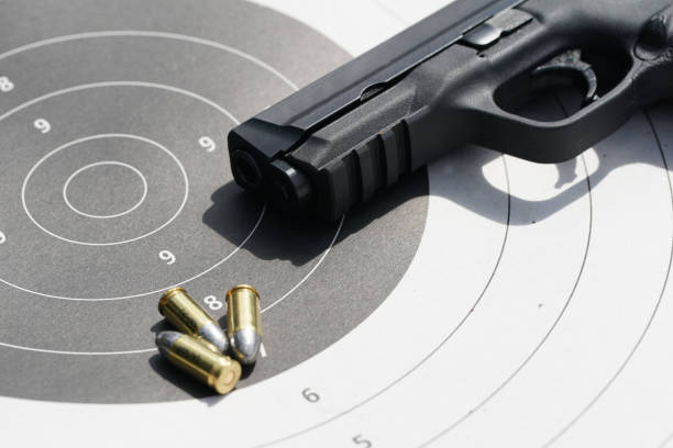 istock gun with 9mm bullets on the target 856589418