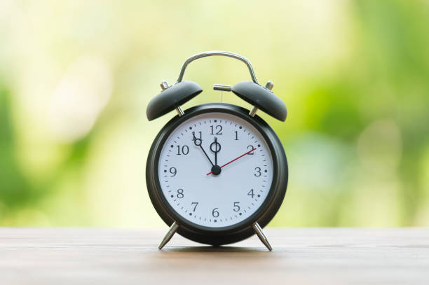 istock Retro alarm clock with five minutes to twelve o'clock. 856589486