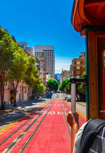 jeździć kolejką linową w san francisco. zdjęcie przedstawia osobę jadącą słynnym pociągiem muni na linii powell-mason w dół wzgórza powell street w san francisco w kalifornii. - hyde street zdjęcia i obrazy z banku zdjęć