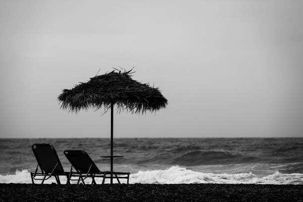 einsam an der kykladen - black sand beach santorini greece stock-fotos und bilder