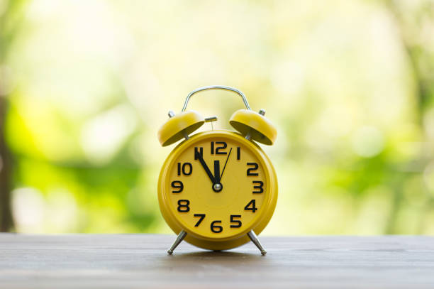 istock Retro alarm clock with five minutes to twelve o'clock. 856604532